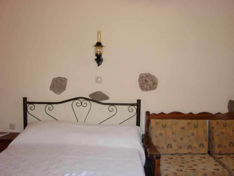 picture of bed in sea-side view Melina Rooms